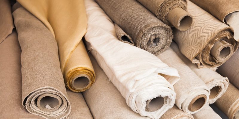 Rolls of  linen cloth lie on the market counter